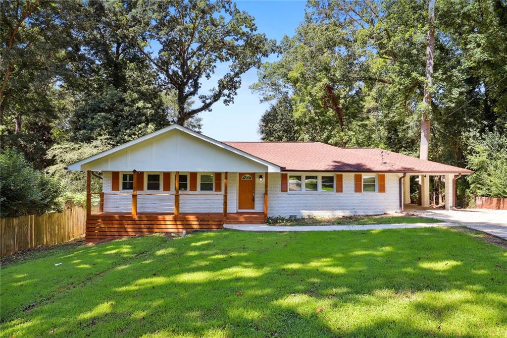 a front view of a house with a garden and trees
