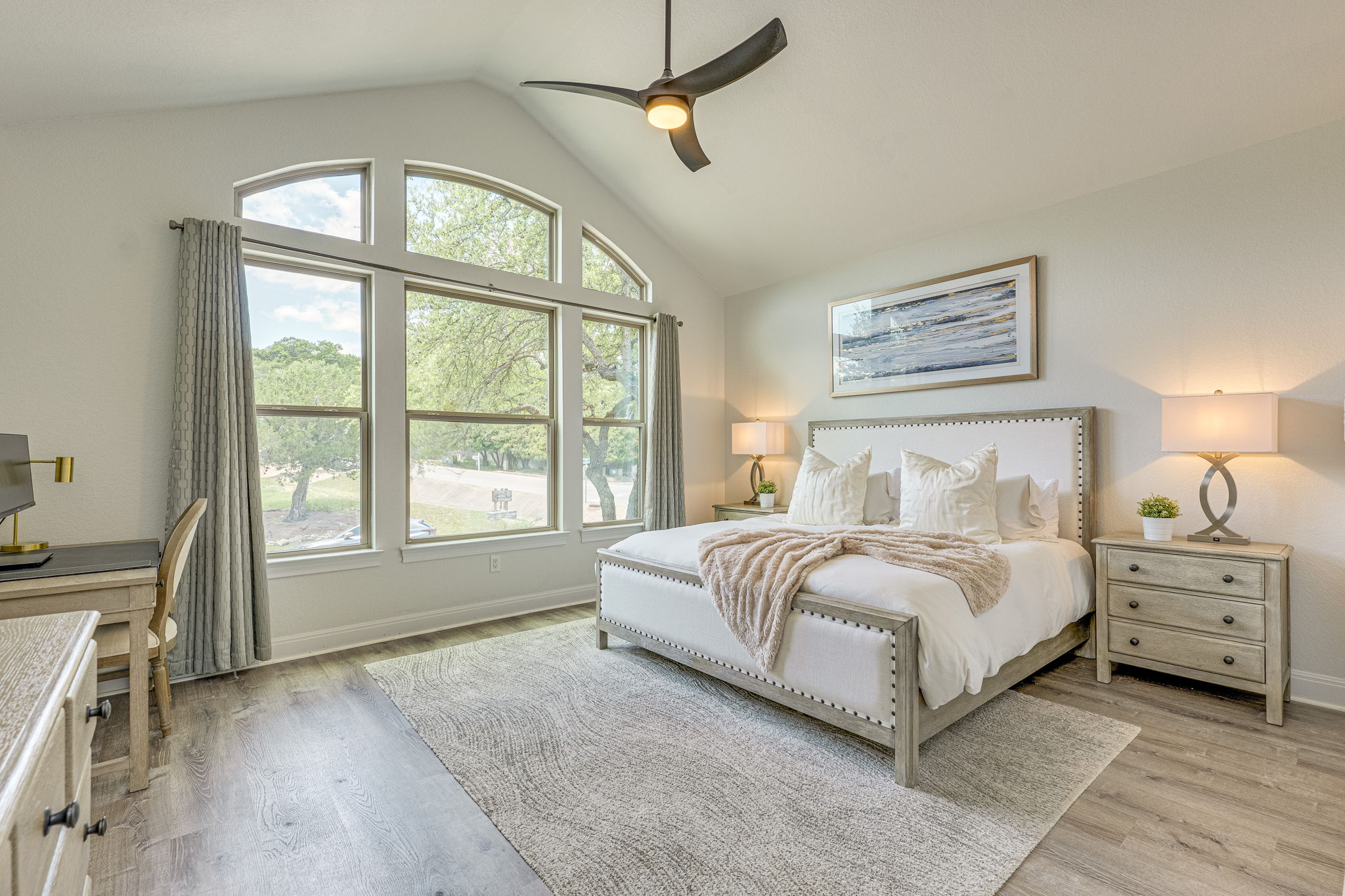433 Venture Boulevard South Point Venture, TX 78645 - Photo 15 of 36 The primary suite sits on the main level and freatures vaulted ceilings, views, and its own ensuite.