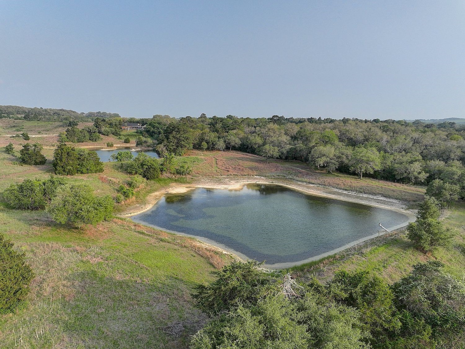 4540 Creamer Creek Road La Grange, TX 78945 - Photo 27 of 32 Aerial view of pond 2 with vast acreage land behind and in the distance.