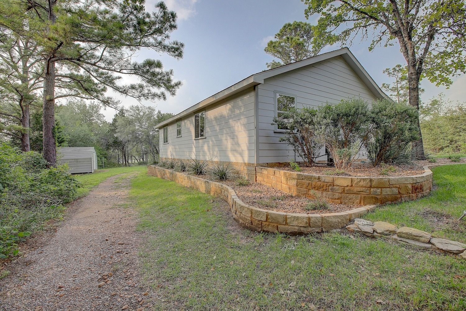 4540 Creamer Creek Road La Grange, TX 78945 - Photo 8 of 32 Side/rear view of the home showing the roadway that leads you to the back acreage. Landscaped zer0-scaping, easily maintained.