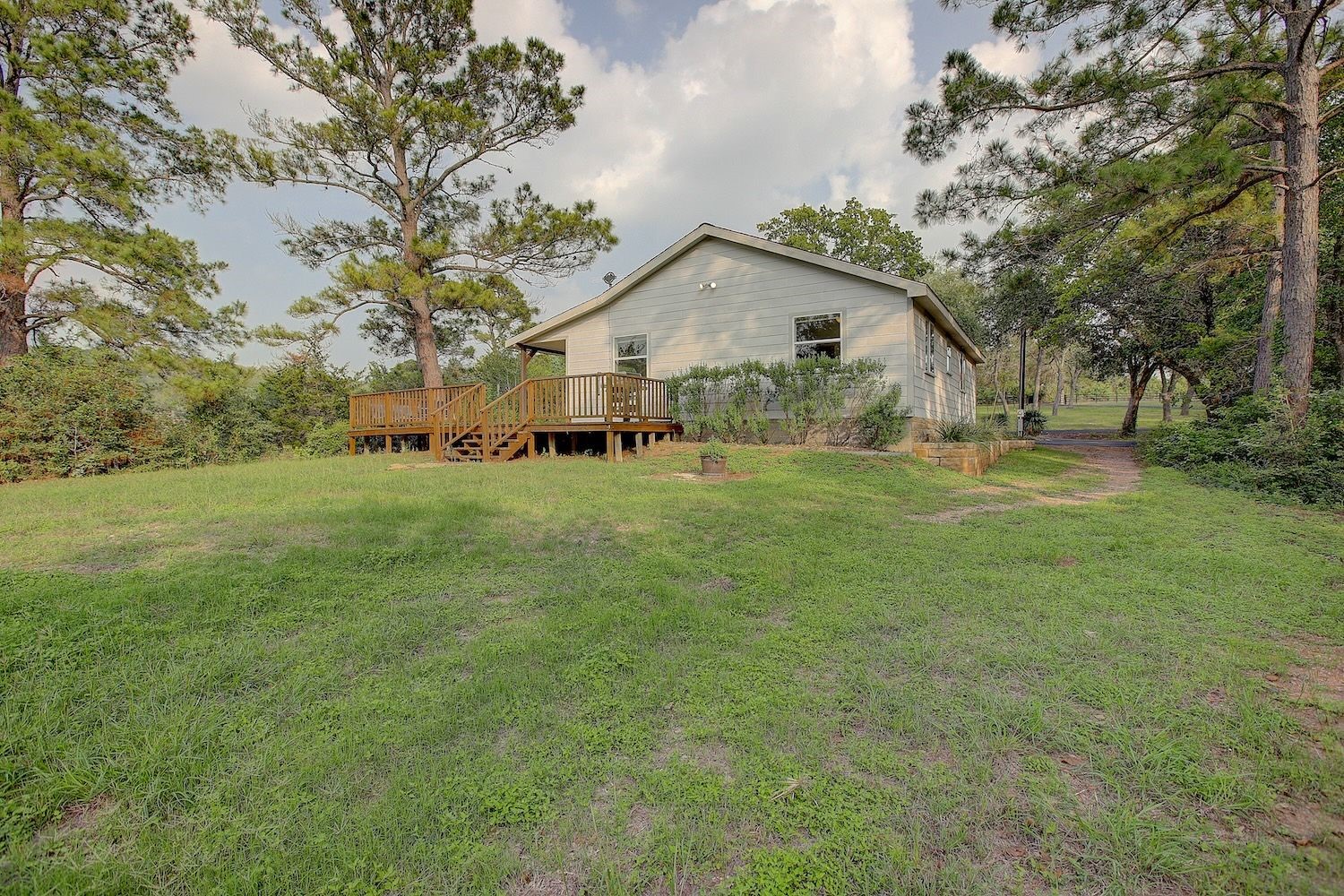 4540 Creamer Creek Road La Grange, TX 78945 - Photo 10 of 32 Standing at the roadway looking toward the home with the decking visible and access available for family gatherings or the private time you deserve.