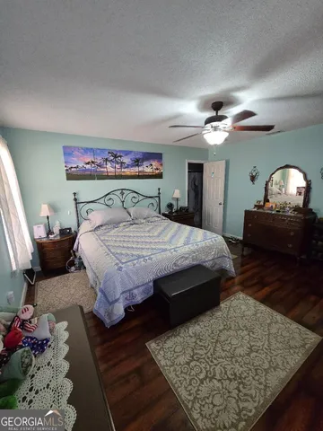 a bedroom with a large bed a chandelier and closet