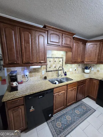 a kitchen with granite countertop wooden cabinets and sink