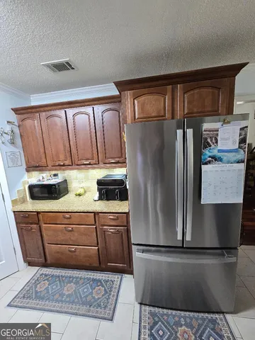 a kitchen with stainless steel appliances granite countertop a refrigerator a stove and a sink with wooden cabinets