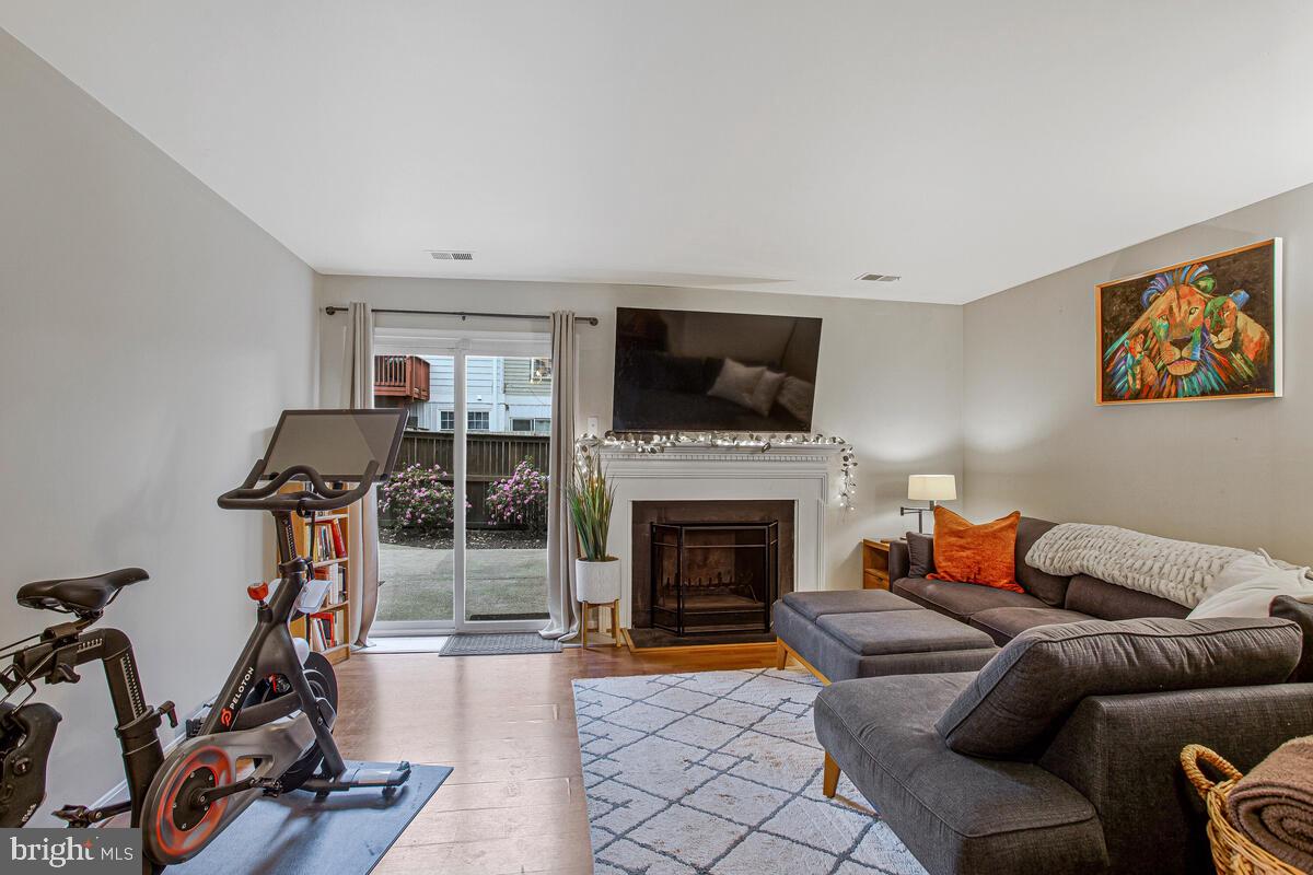 1438 Orleans Court Crofton, MD 21114 - Photo 16 of 26 a living room with furniture a flat screen tv and a fireplace