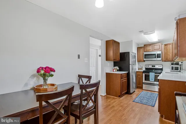a kitchen with a dining table chairs microwave and refrigerator