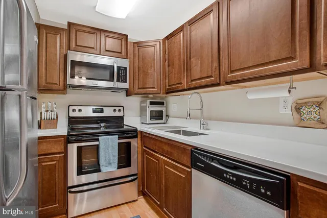 a kitchen with stainless steel appliances a stove microwave and sink
