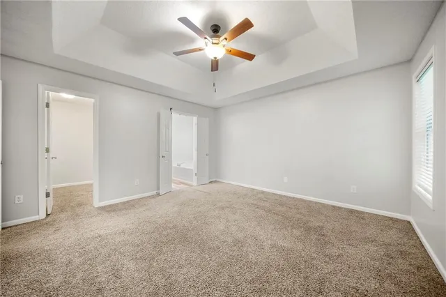an empty room with closet and a ceiling fan
