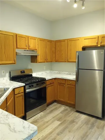 a kitchen with granite countertop a refrigerator stove top oven and sink