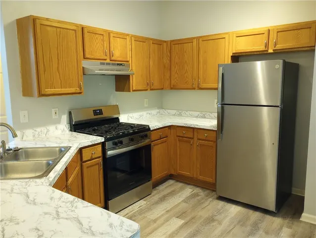 a kitchen with stainless steel appliances granite countertop a refrigerator sink and cabinets