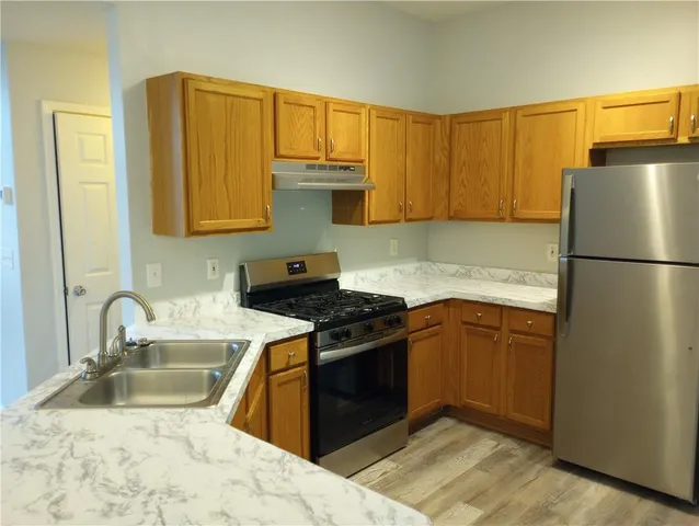 a kitchen with granite countertop a sink stove and refrigerator