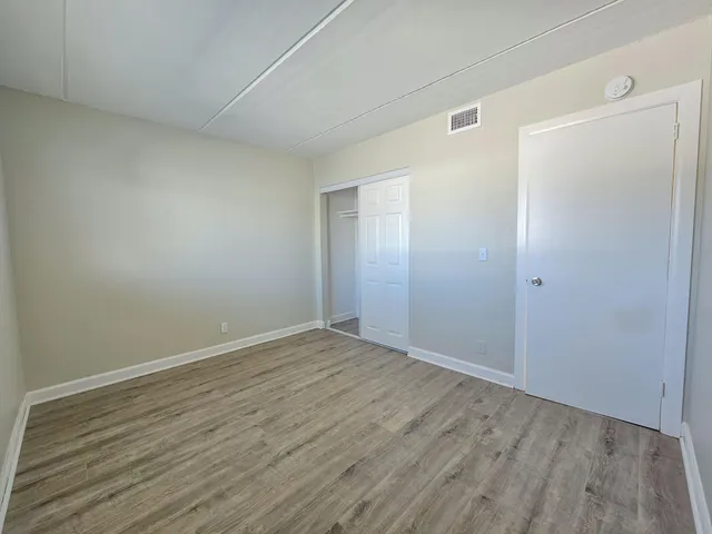 a view of an empty room with wooden floor