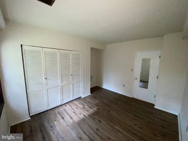 an empty room with wooden floor and cabinet