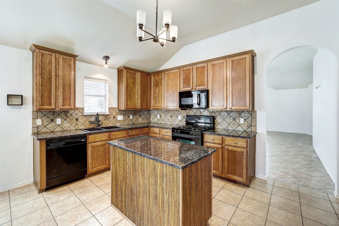 1517 Rainbow Parke Drive Round Rock, TX 78665 - Photo 11 of 38 a kitchen with stainless steel appliances granite countertop a stove top oven a sink dishwasher a refrigerator and a microwave