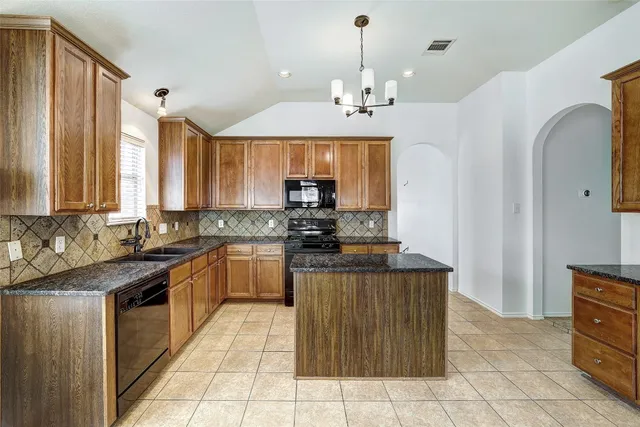 a kitchen with a sink window and cabinets