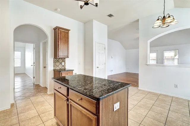 a kitchen with kitchen island granite countertop a stove a sink and a refrigerator