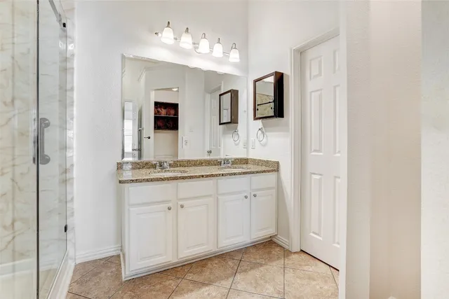 a spacious bathroom with a granite countertop sink and a mirror