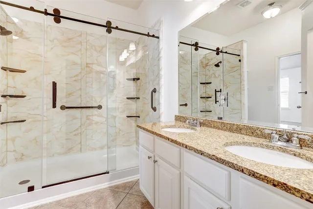 a bathroom with a granite countertop shower sink and mirror