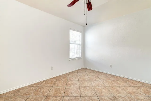 an empty room with a window and a ceiling fan