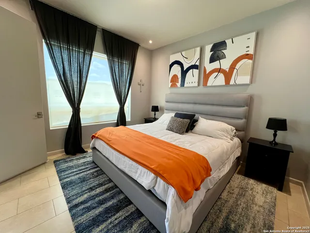 a bedroom with a bed and a large window