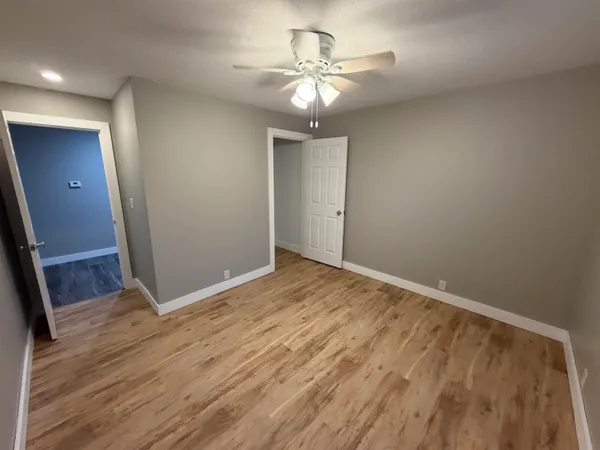 a view of empty room with wooden floor