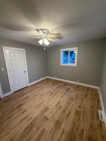 a view of an empty room with wooden floor