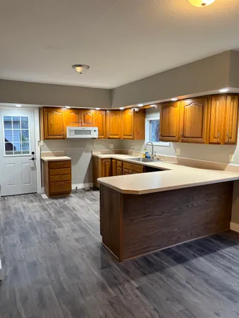 a large kitchen with stainless steel appliances granite countertop a stove and a sink