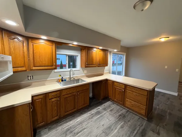 a large kitchen with a table chairs microwave and refrigerator