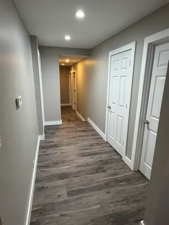 an empty room with wooden floor and painting on the wall