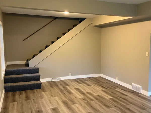 a view of a room with wooden floor and a ceiling fan