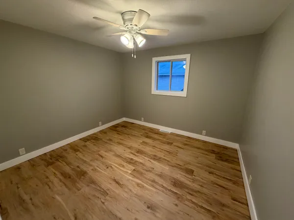 an empty room with wooden floor and entrance