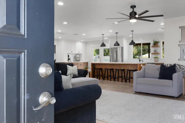 a kitchen with stainless steel appliances kitchen island granite countertop a table chairs stove and refrigerator