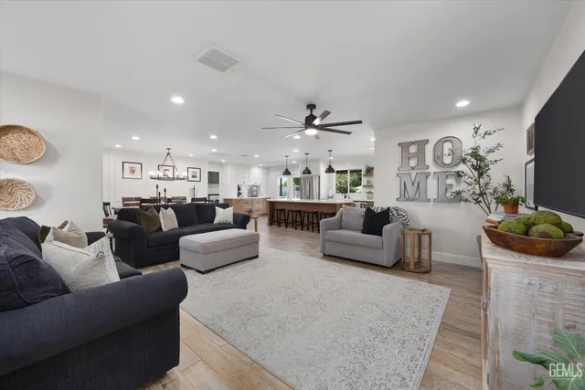 a kitchen with stainless steel appliances granite countertop a refrigerator a sink dishwasher and a stove with wooden floor