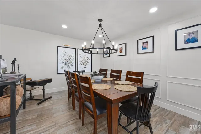 a large kitchen with stainless steel appliances a sink a stove and a wooden floor