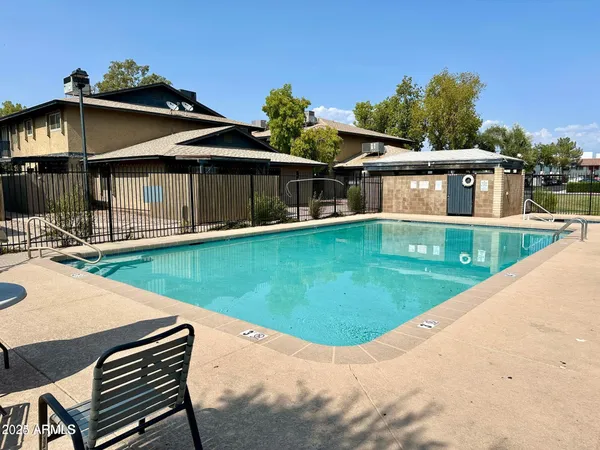 a view of a house with pool and chairs