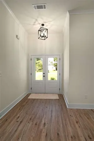 an empty room with wooden floor and window