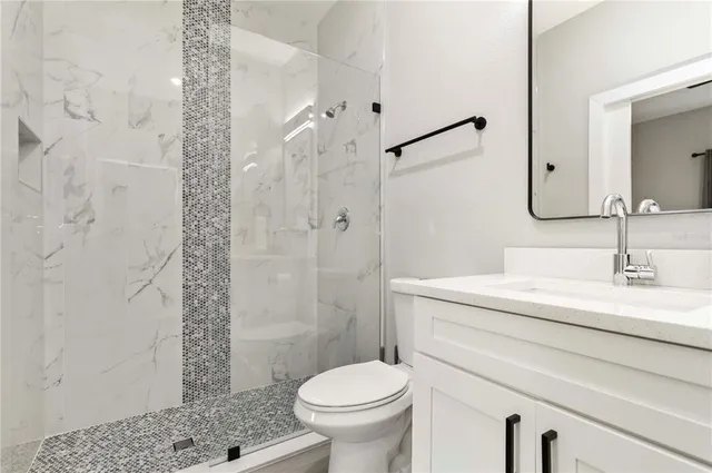 a bathroom with a sink a toilet and shower