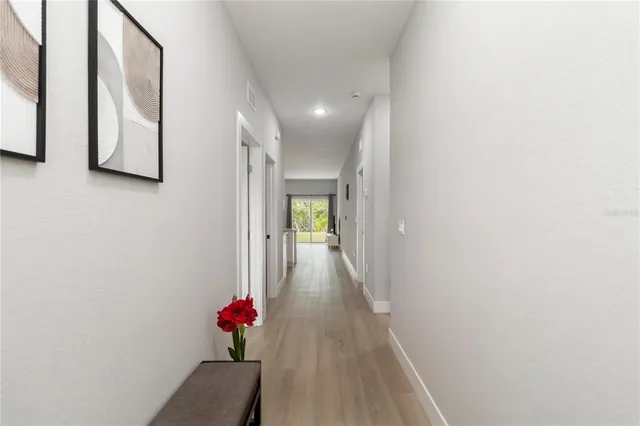 a view of a hallway with wooden floor and glass door