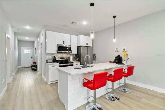 a kitchen with granite countertop a stove a sink and a wooden floors