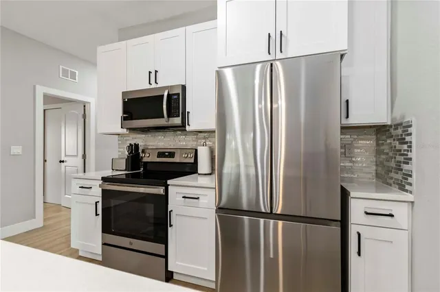 a kitchen with stainless steel appliances a refrigerator stove and microwave