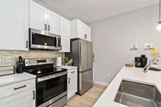 a kitchen with refrigerator a microwave a stove and cabinets