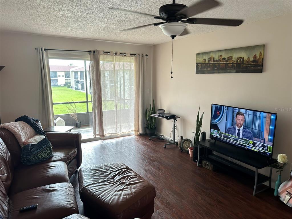 5154 Turquoise Lane, Unit 206 New Port Richey, FL 34652 - Photo 28 of 54 a living room with furniture a flat screen tv and a window