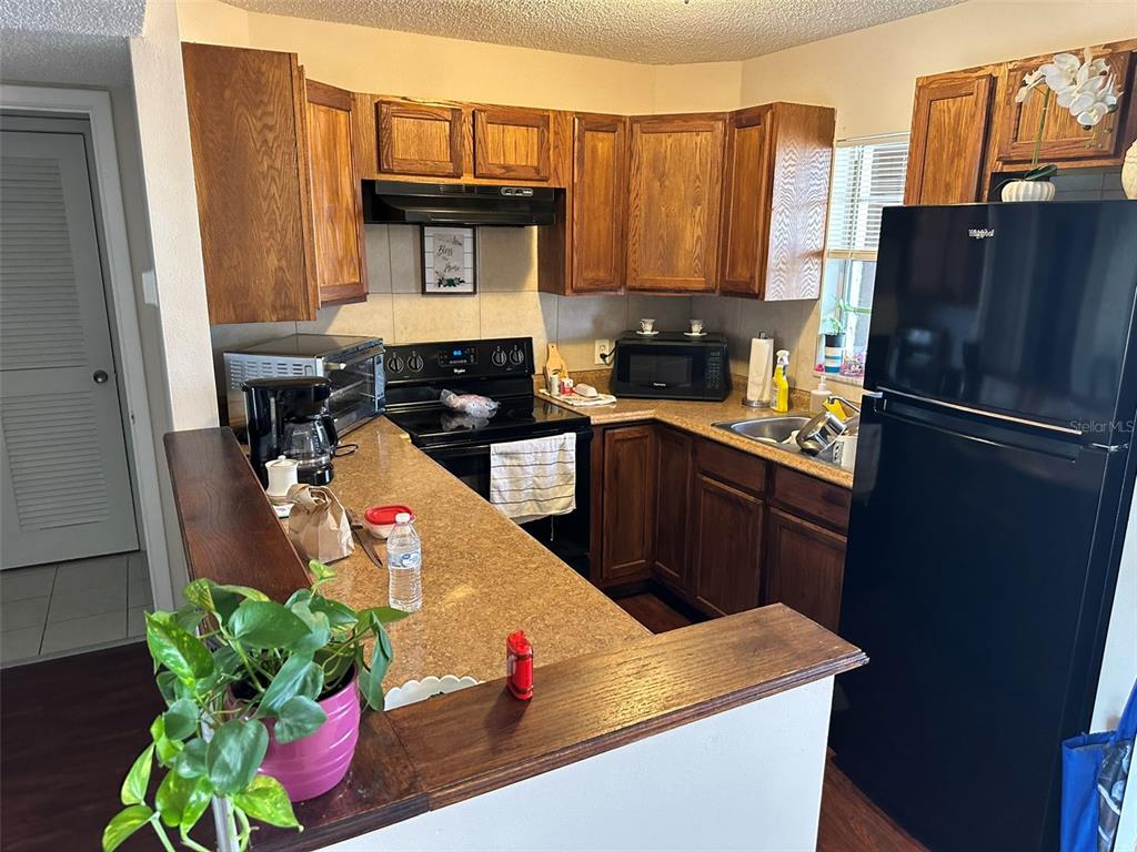 5154 Turquoise Lane, Unit 206 New Port Richey, FL 34652 - Photo 30 of 54 a kitchen with stainless steel appliances granite countertop a refrigerator a stove a sink dishwasher and a microwave