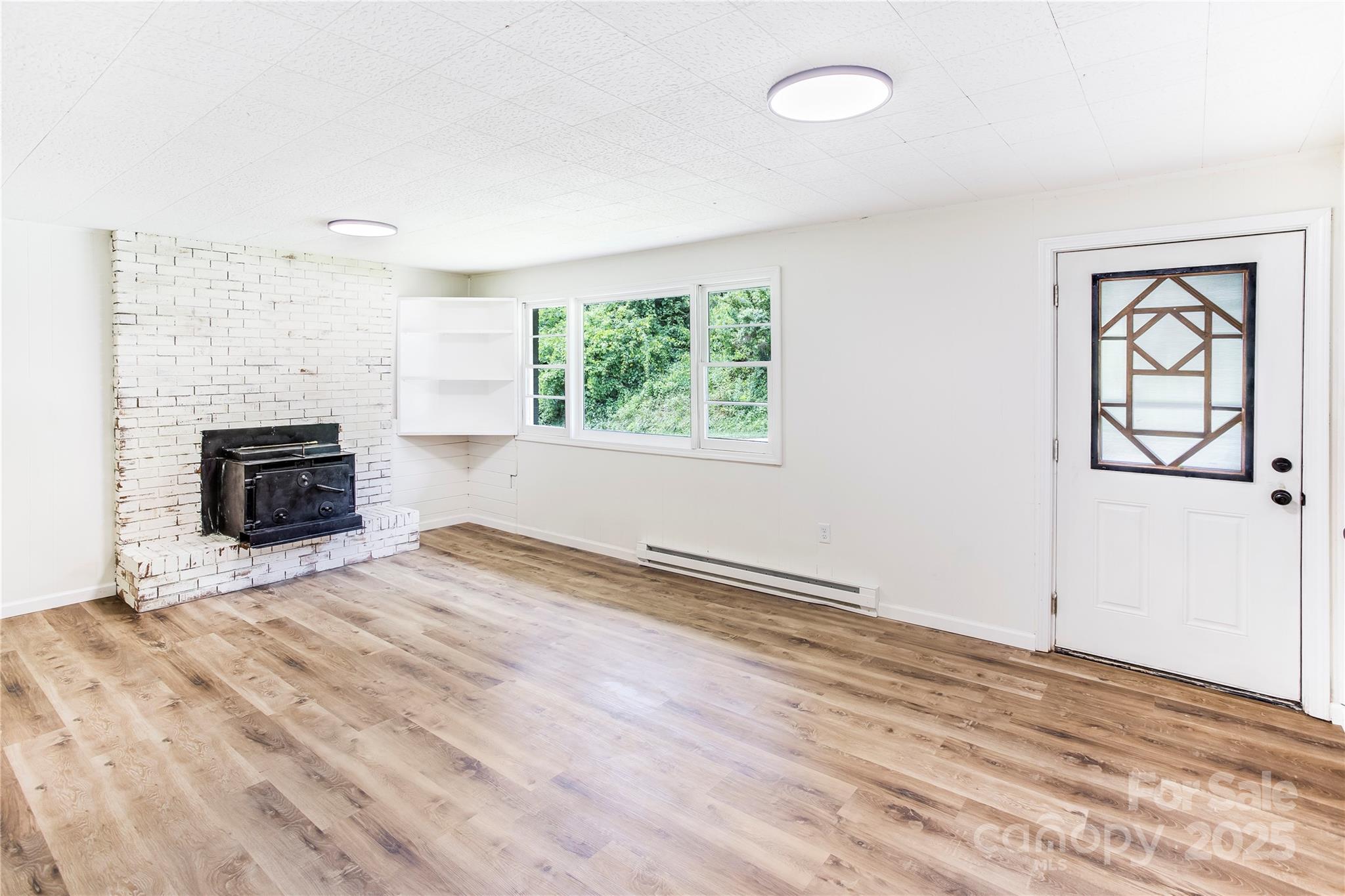 76 Trent Road Brevard, NC 28712 - Photo 8 of 31 an empty room with windows and fireplace