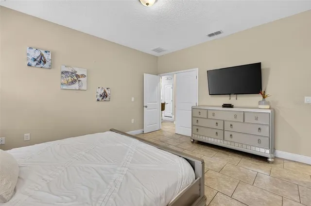 a bedroom with a bed and flat screen tv
