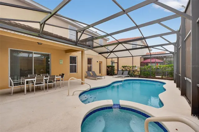 a view of a swimming pool with a dining table and chairs