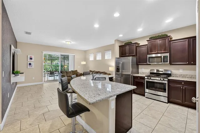 a kitchen with stainless steel appliances granite countertop a sink dishwasher stove top oven and refrigerator