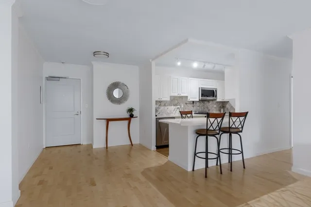 a kitchen with a table chairs refrigerator and microwave