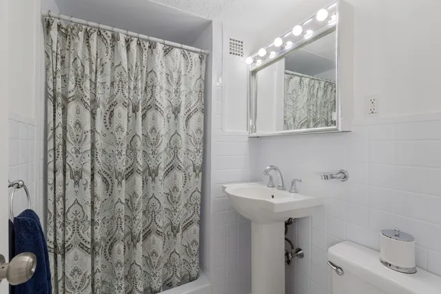 a bathroom with a sink toilet and mirror