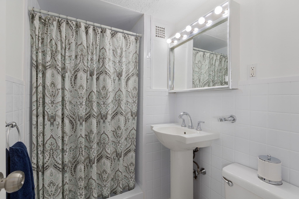 6 Whittier Place, Unit 7E Boston, MA 02114 - Photo 24 of 33 a bathroom with a sink toilet and mirror